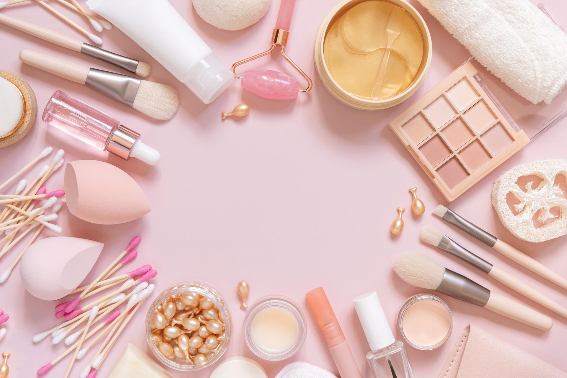 Natural skin care and decorative cosmetics on light pink, top view, copy space